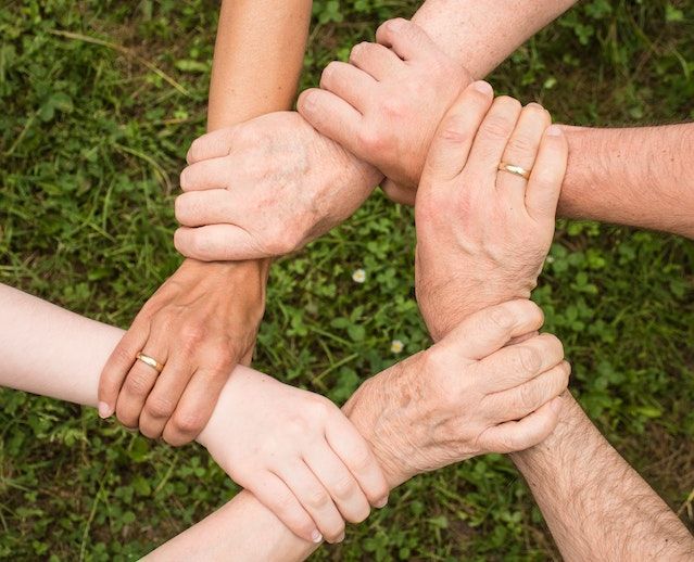 Young and elderly holding hands in a circle